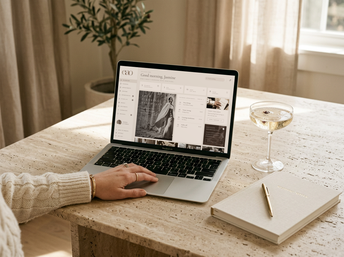 A laptop showing the Ever After Ours planning dashboard on a travertine table